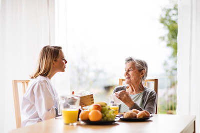 Caregiver visiting with patient at home